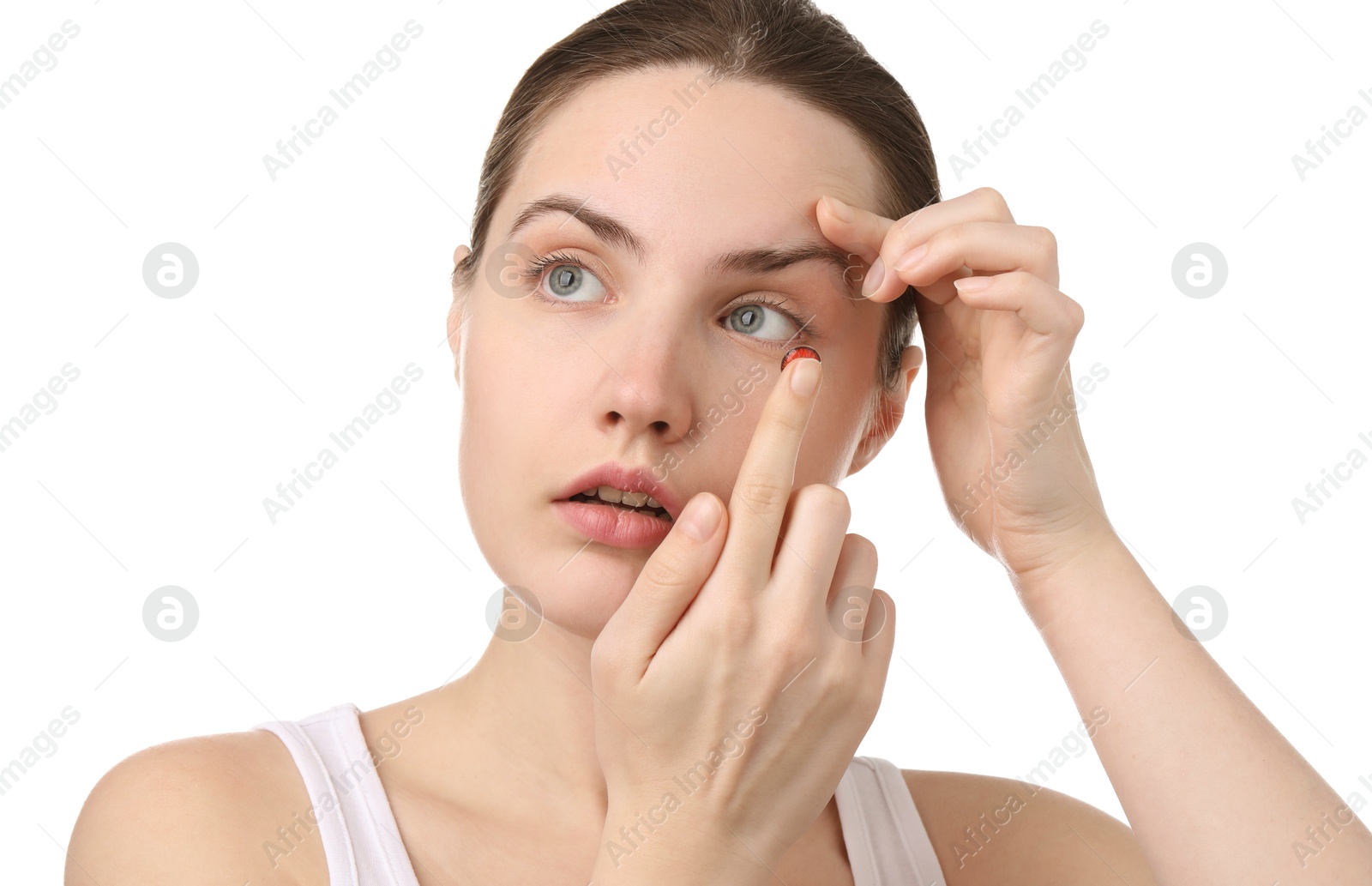 Photo of Young woman putting in red color contact lens on white background