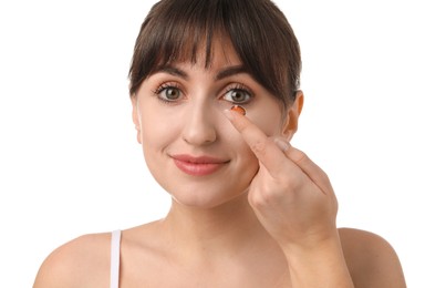 Photo of Young woman putting in red color contact lens on white background