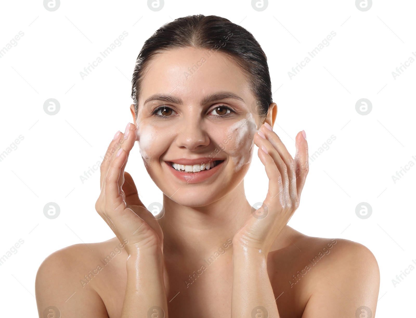 Photo of Smiling woman washing her face with cleansing foam on white background