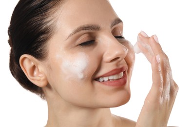 Photo of Smiling woman washing her face with cleansing foam on white background, closeup