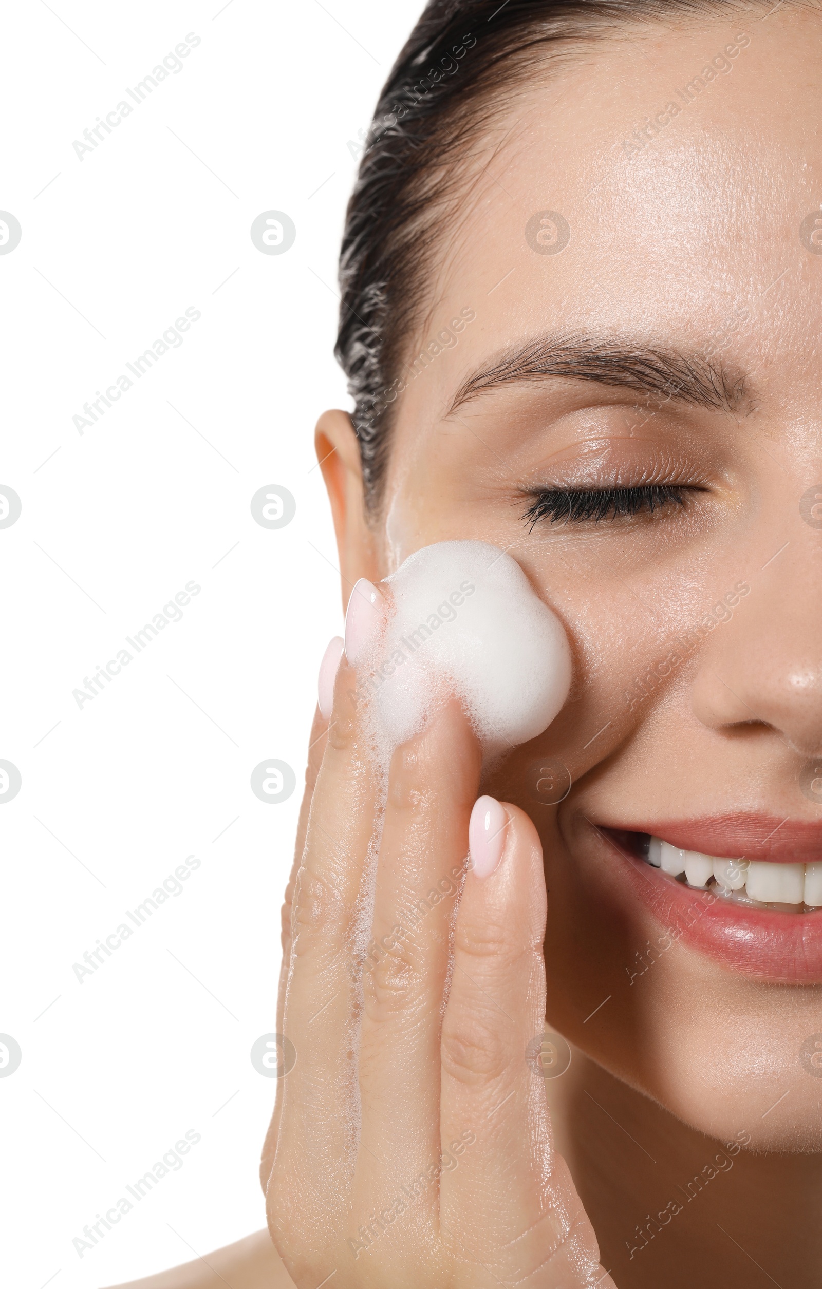 Photo of Smiling woman washing her face with cleansing foam on white background, closeup