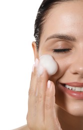 Photo of Smiling woman washing her face with cleansing foam on white background, closeup