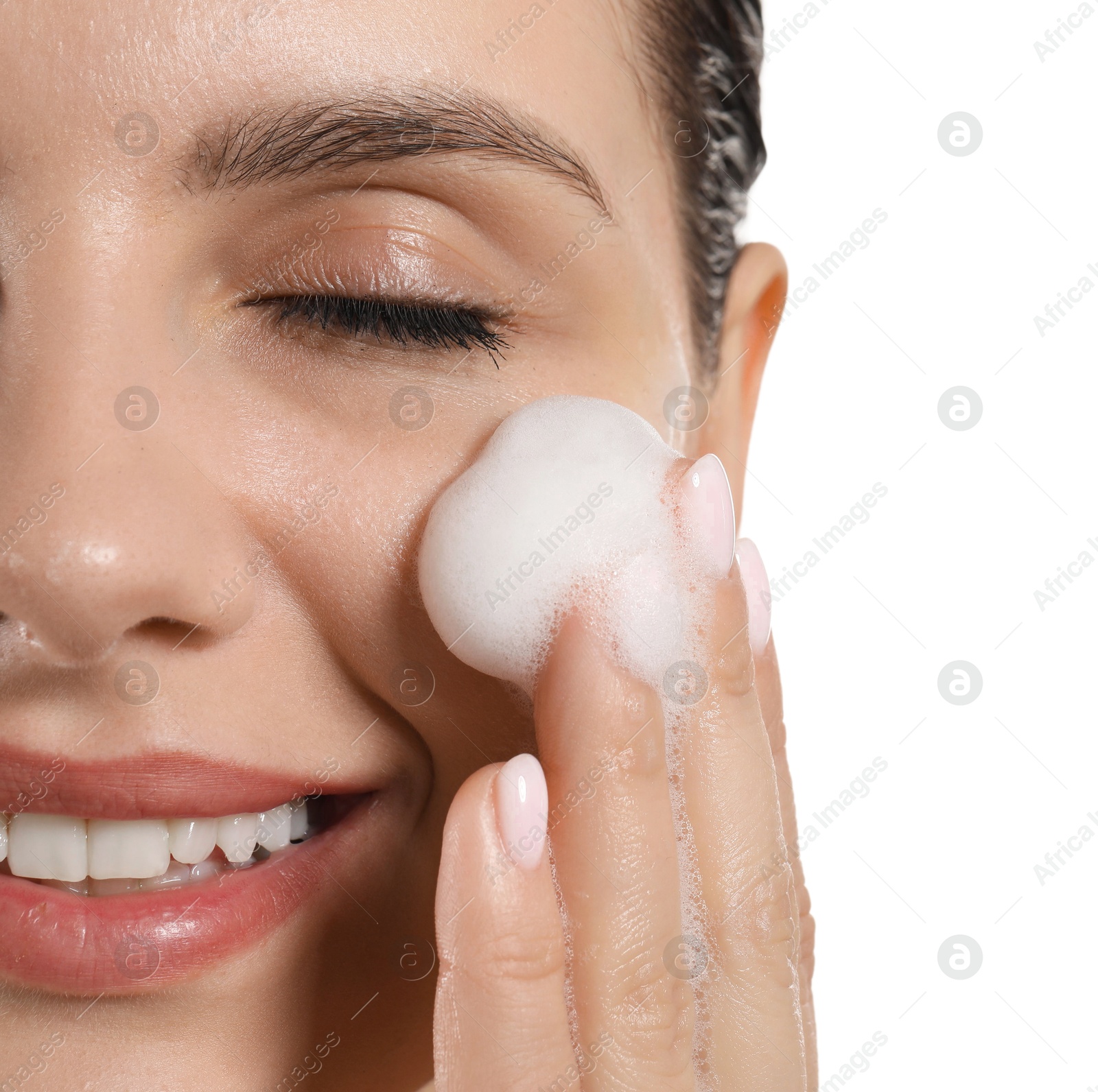 Photo of Smiling woman washing her face with cleansing foam on white background, closeup