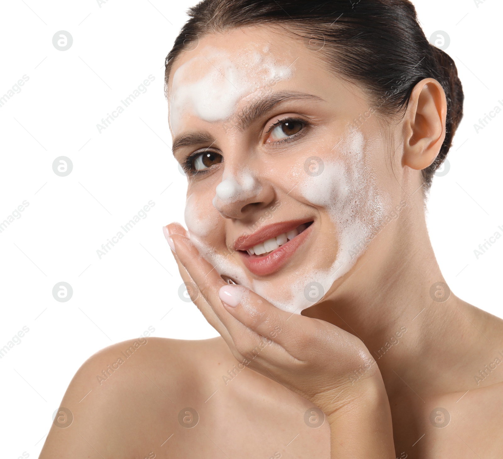 Photo of Smiling woman washing her face with cleansing foam on white background