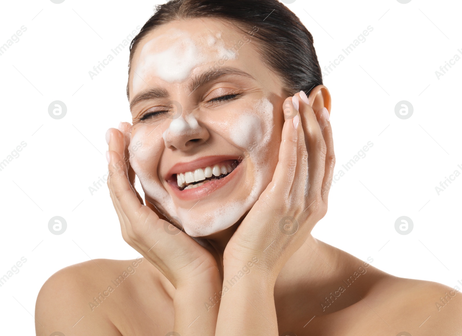 Photo of Smiling woman washing her face with cleansing foam on white background