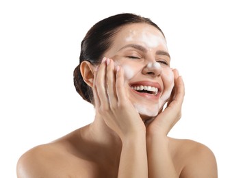 Photo of Smiling woman washing her face with cleansing foam on white background