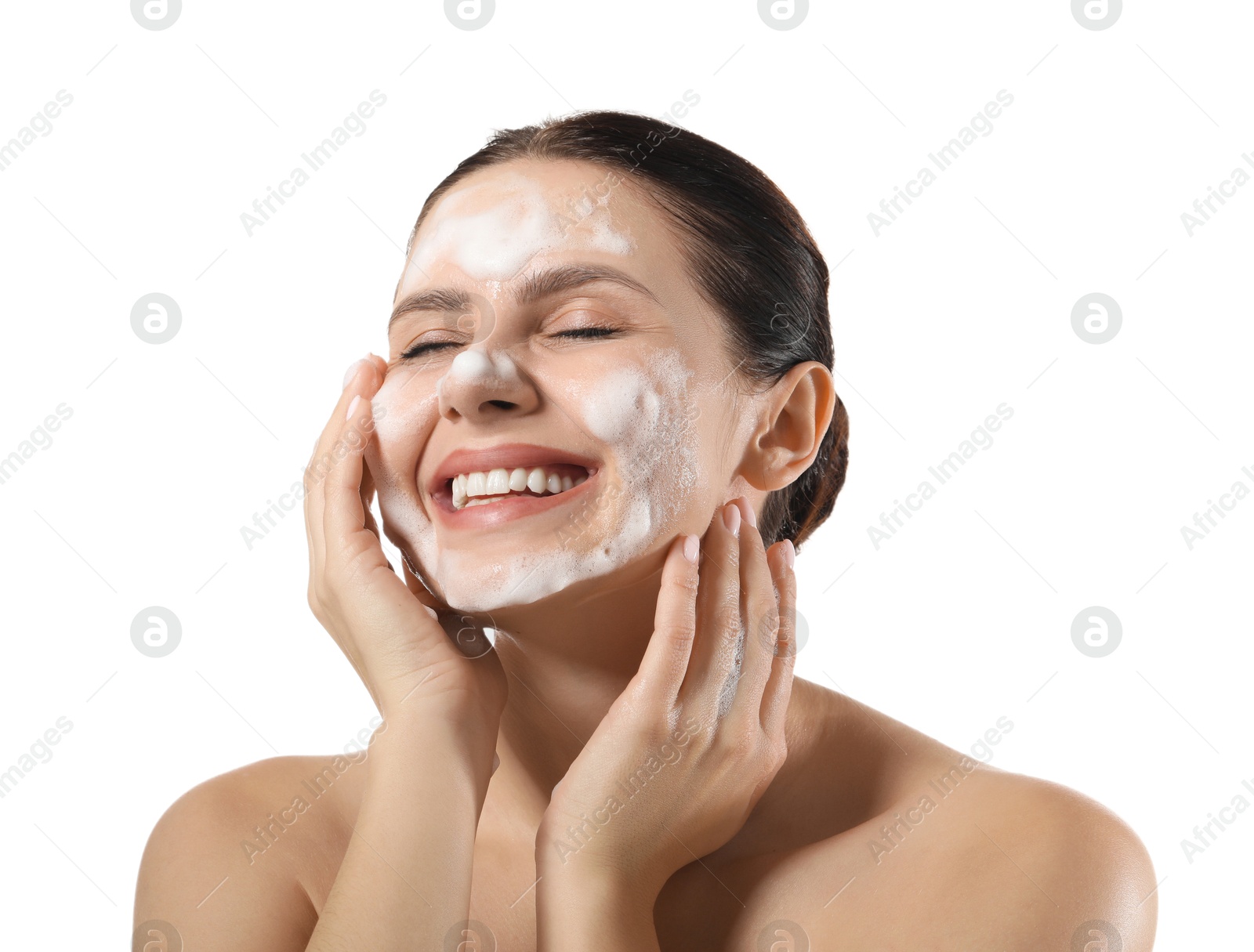 Photo of Smiling woman washing her face with cleansing foam on white background