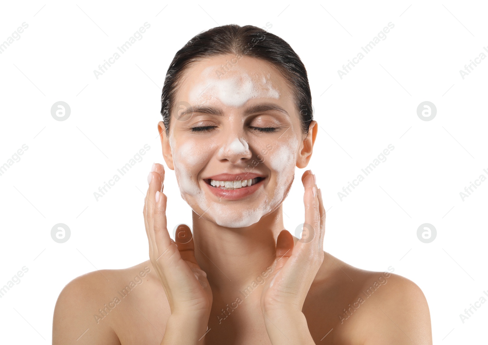 Photo of Smiling woman washing her face with cleansing foam on white background