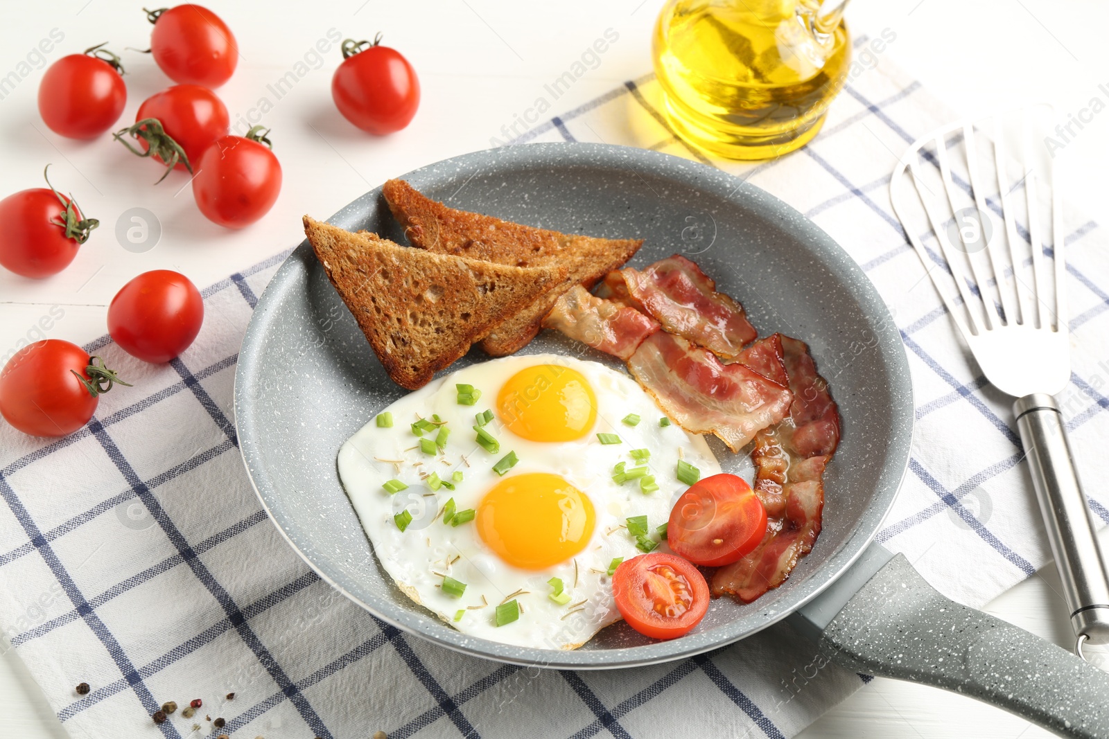 Photo of Tasty fried eggs with bacon and toasts served on white table, closeup