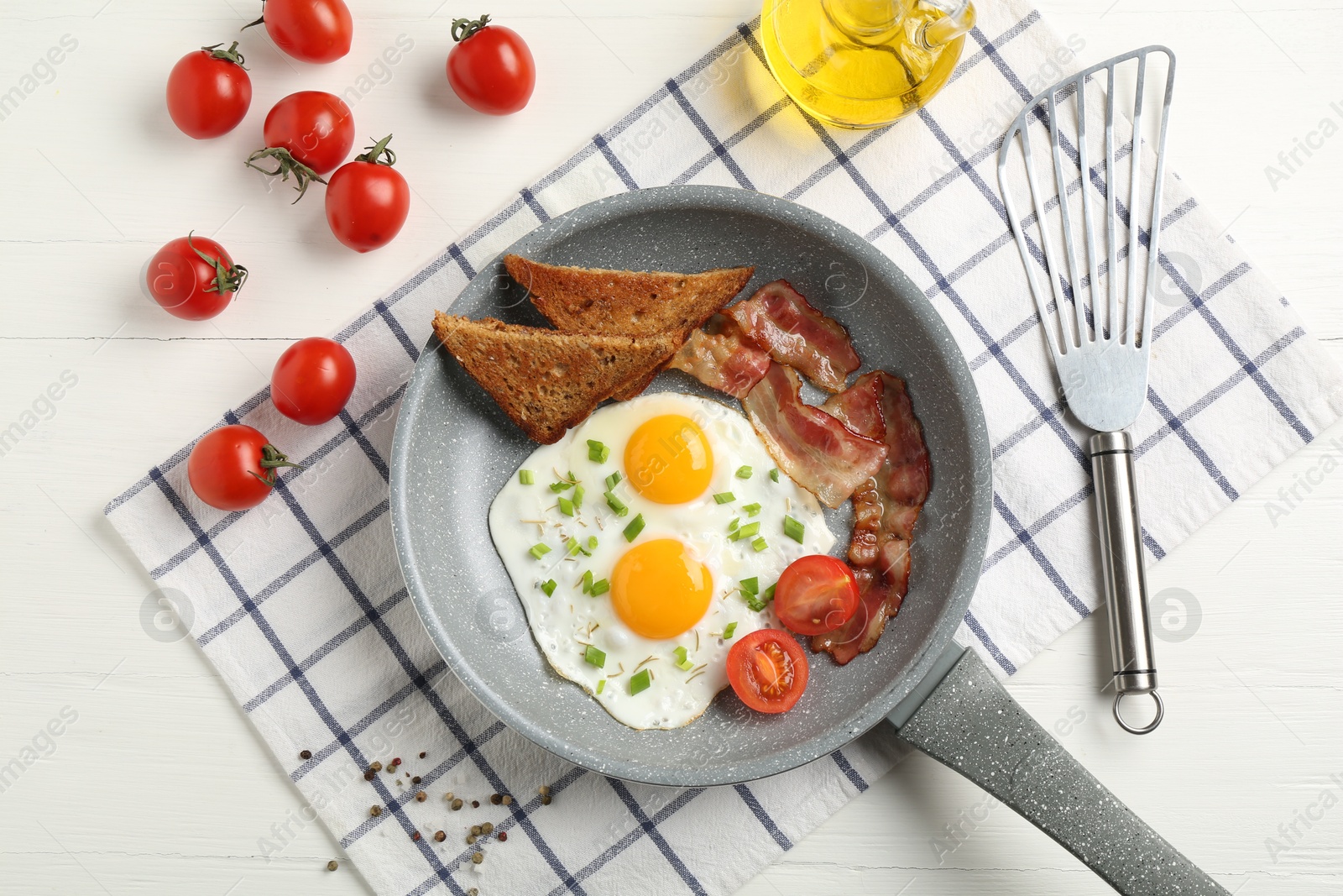 Photo of Tasty fried eggs with bacon and toasts served on white wooden table, flat lay