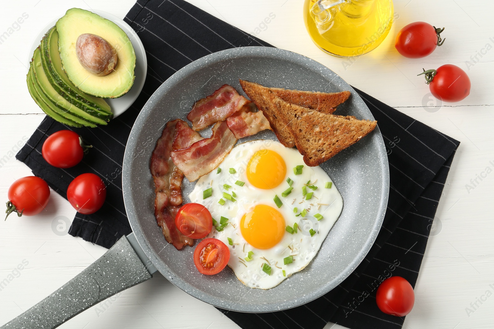 Photo of Tasty fried eggs with bacon and toasts served on white wooden table, flat lay