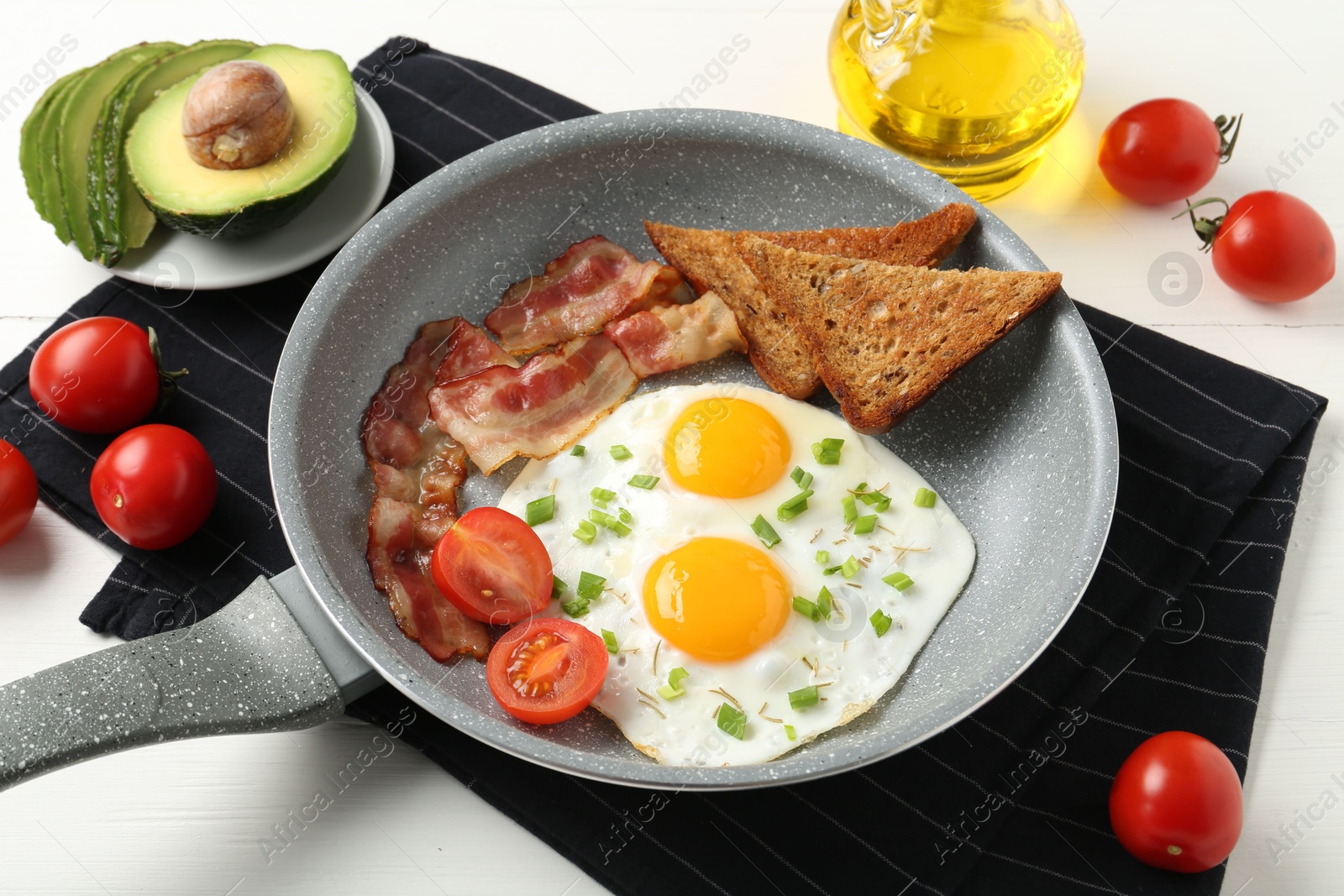 Photo of Tasty fried eggs with bacon and toasts served on white wooden table, closeup