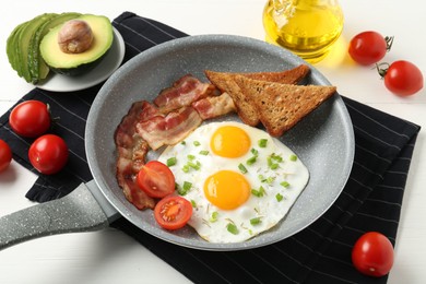 Photo of Tasty fried eggs with bacon and toasts served on white wooden table, closeup