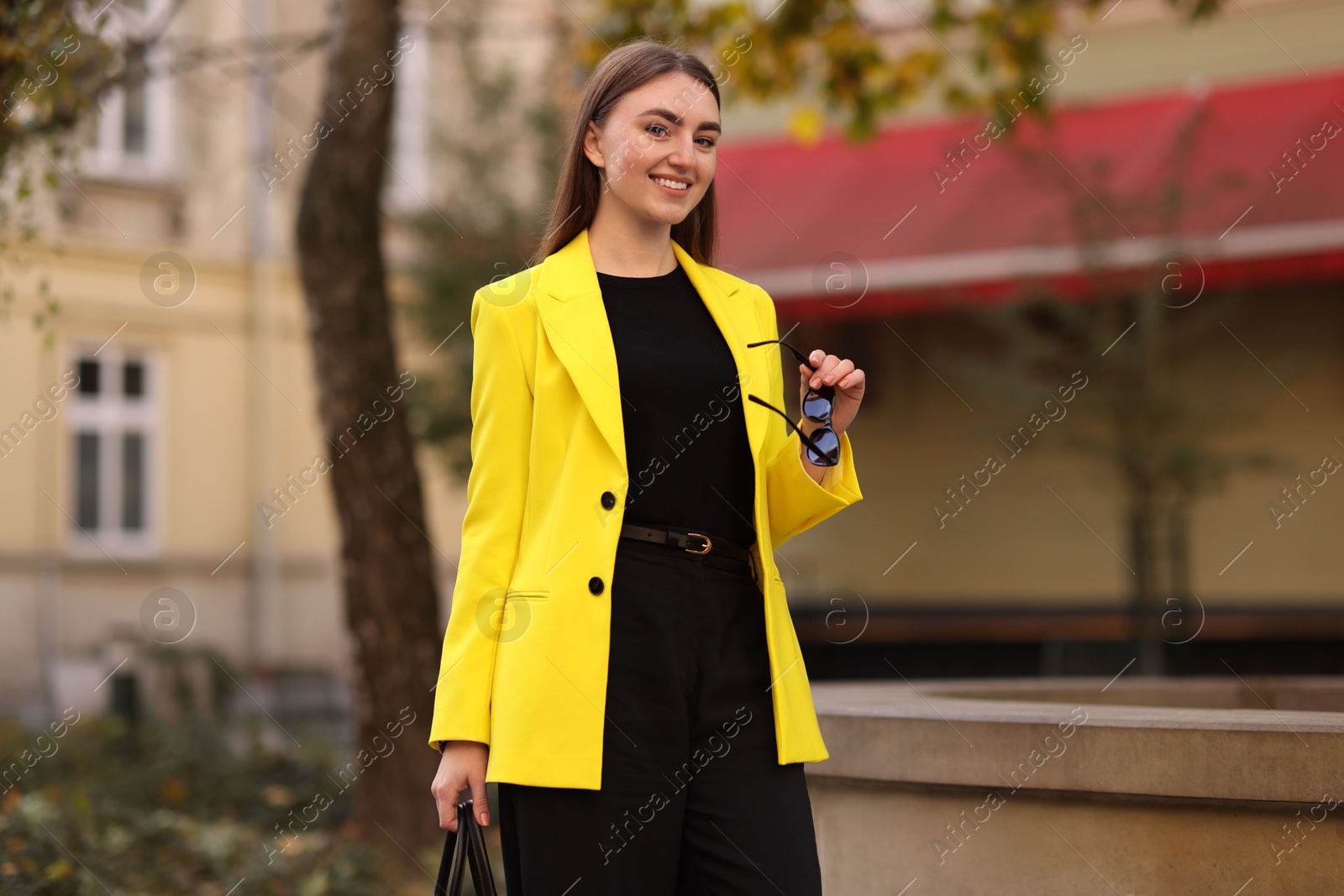 Photo of Smiling businesswoman in stylish suit on city street