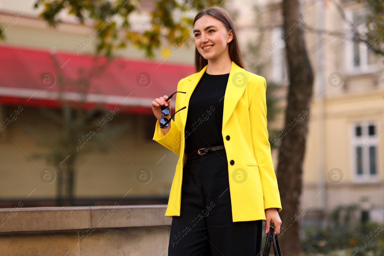 Photo of Beautiful woman in stylish suit outdoors. Space for text