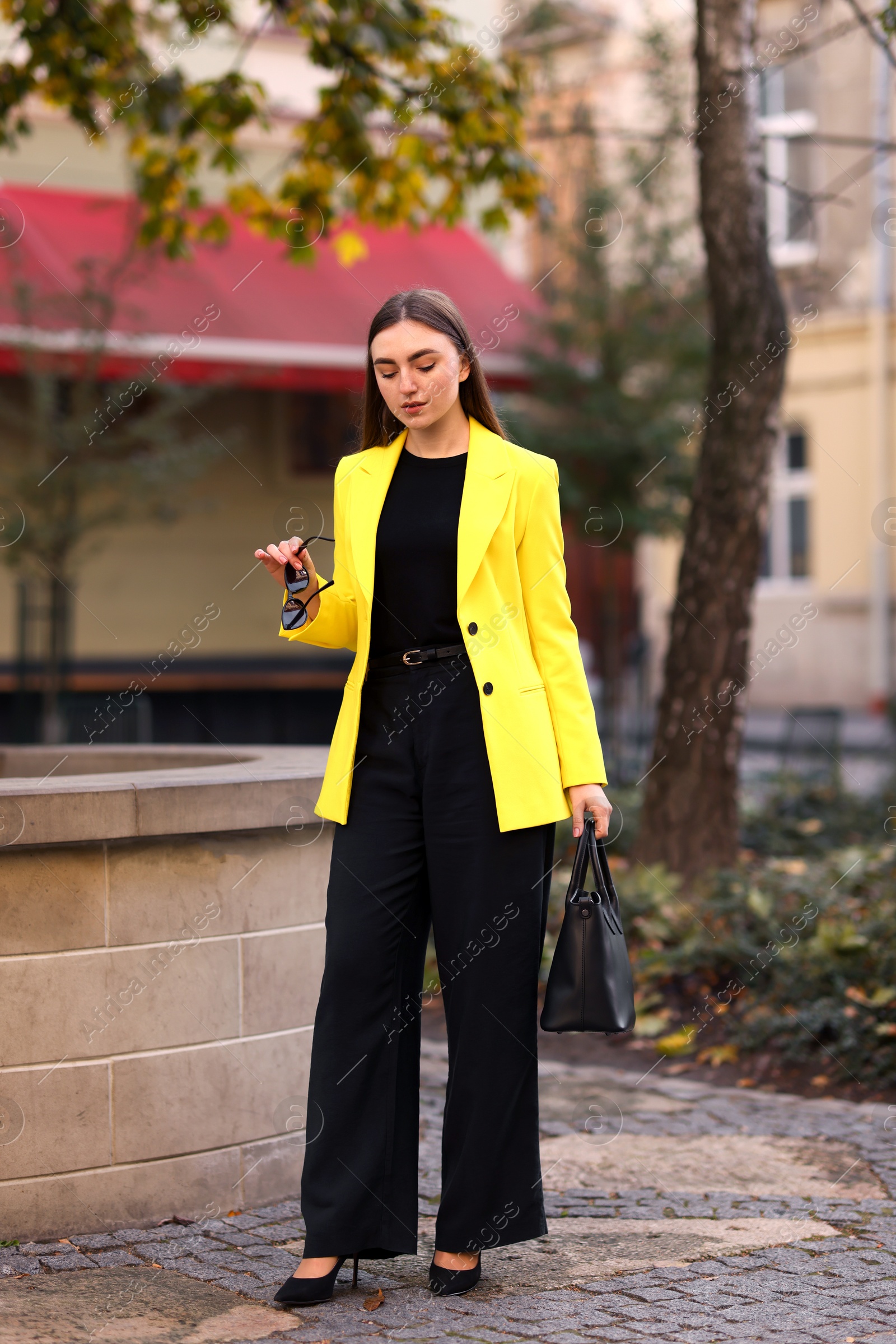 Photo of Beautiful businesswoman in stylish suit on city street