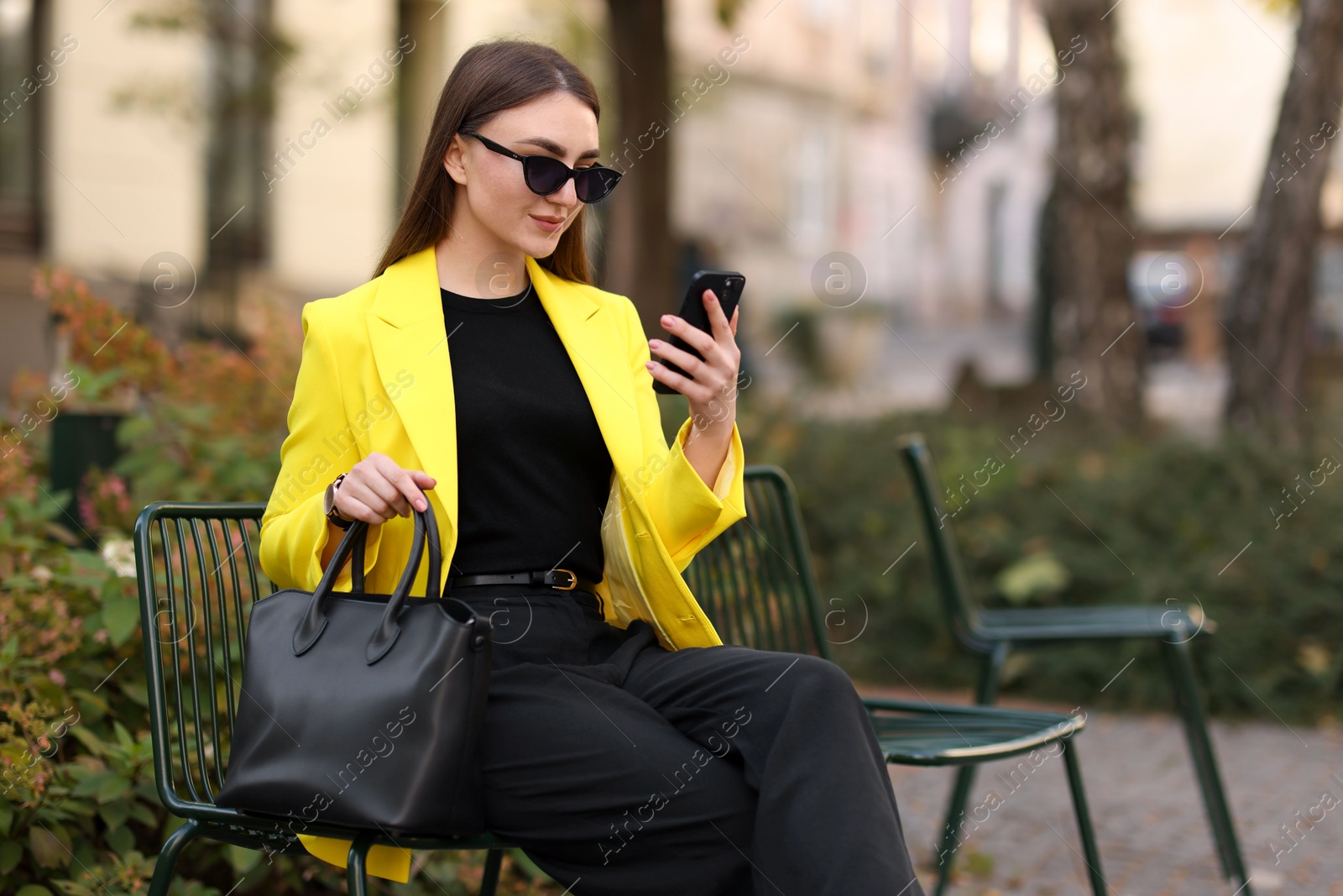 Photo of Businesswoman in stylish suit with smartphone outdoors. Space for text