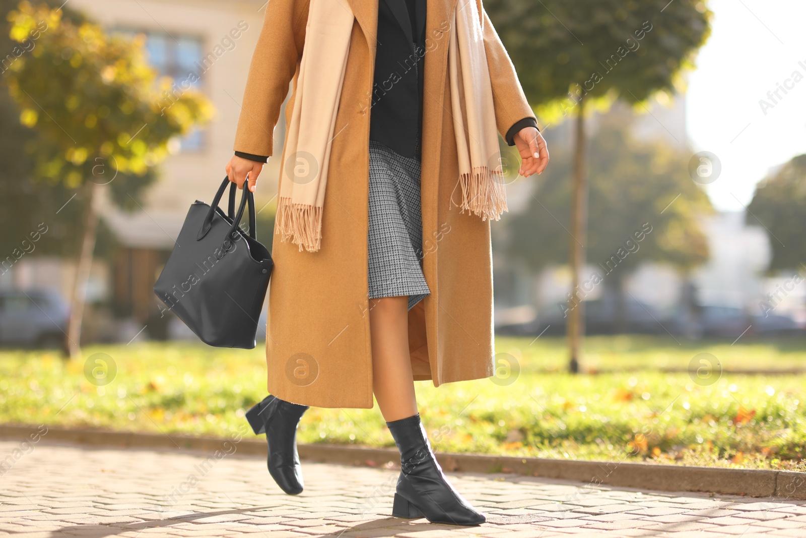 Photo of Businesswoman in stylish suit walking outdoors, closeup