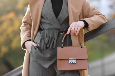 Photo of Businesswoman in stylish suit with bag outdoors, closeup view