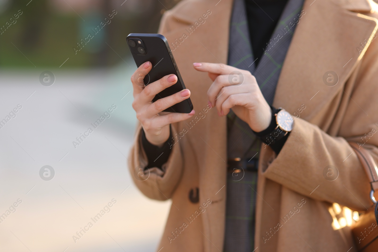 Photo of Businesswoman in stylish suit using smartphone outdoors, closeup. Space for text