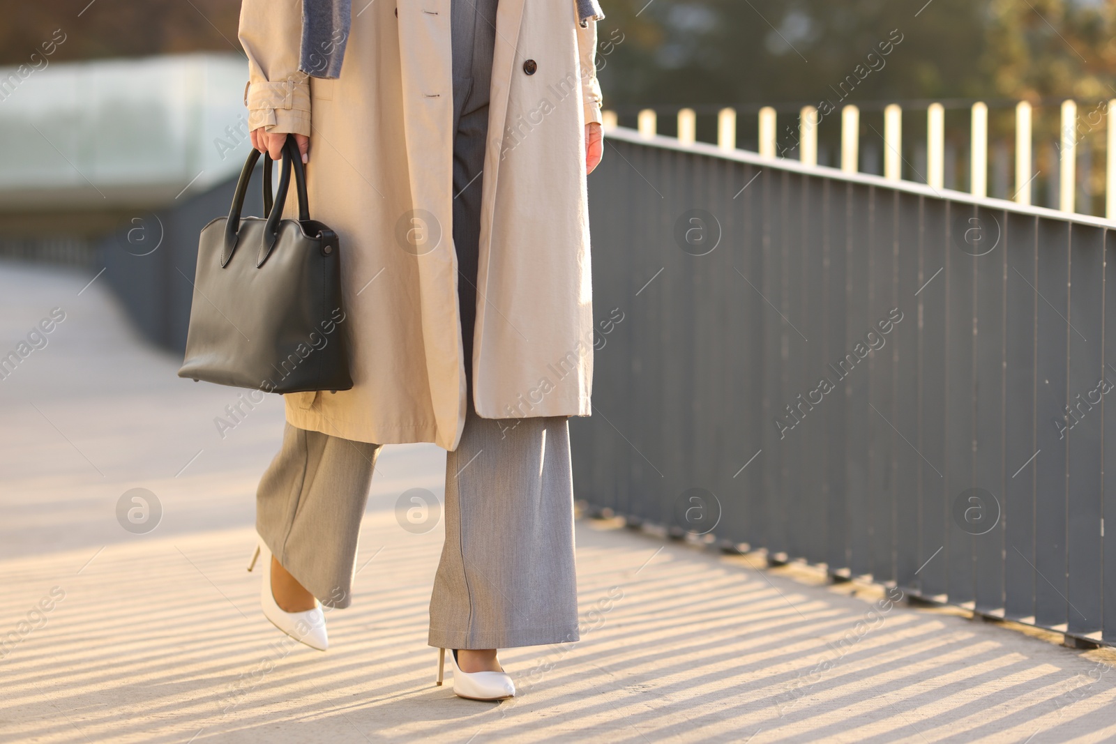 Photo of Businesswoman in stylish suit walking outdoors, closeup. Space for text