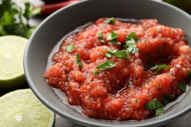 Photo of Delicious spicy salsa sauce in bowl on table, closeup