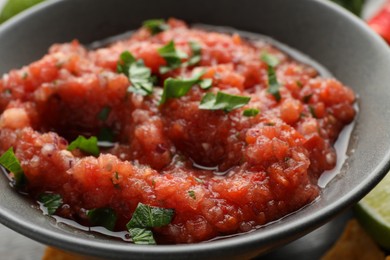 Photo of Delicious spicy salsa sauce in bowl on table, closeup