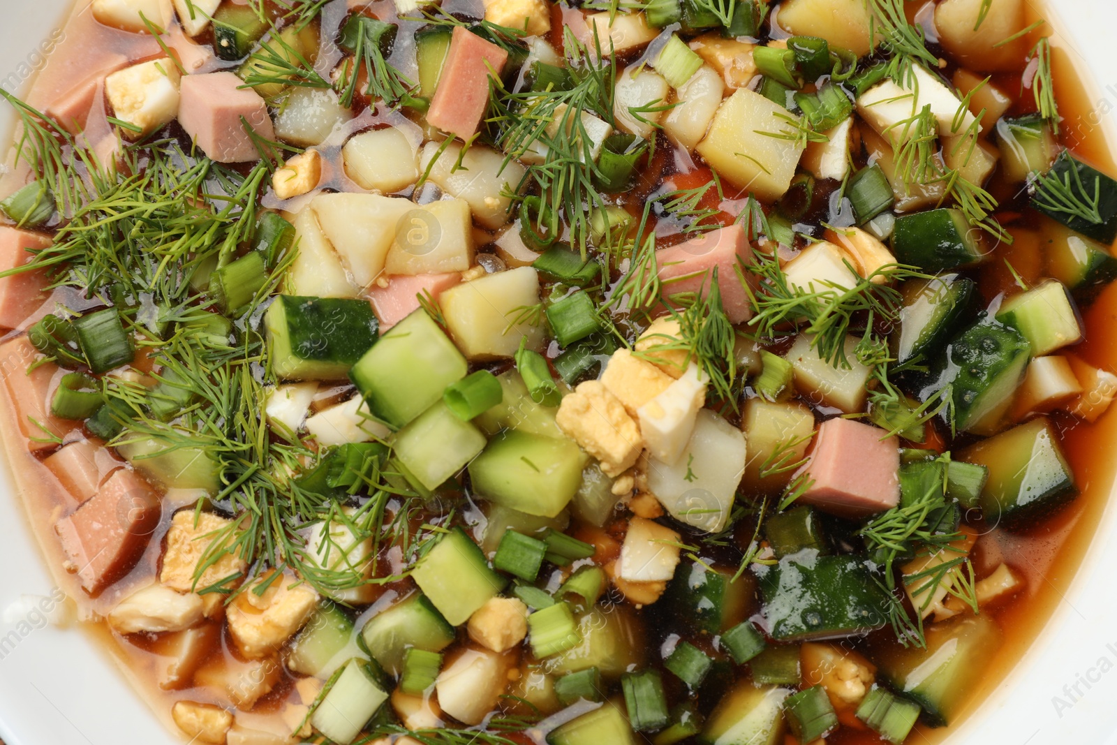 Photo of Tasty okroshka soup with kvass in bowl, top view