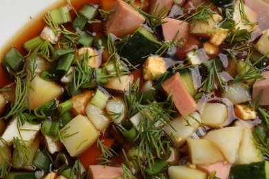 Photo of Tasty okroshka soup with kvass in bowl, top view