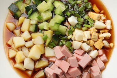 Photo of Tasty okroshka soup with kvass in bowl, top view