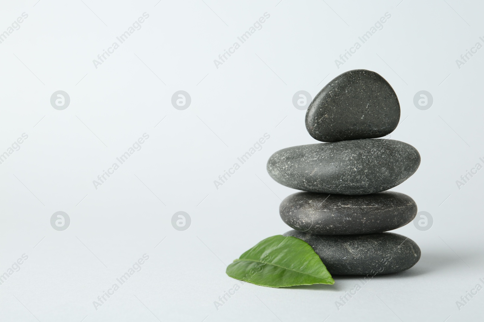 Photo of Stack of rocks on light background, space for text. Harmony and life balance