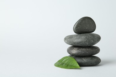 Photo of Stack of rocks on light background, space for text. Harmony and life balance