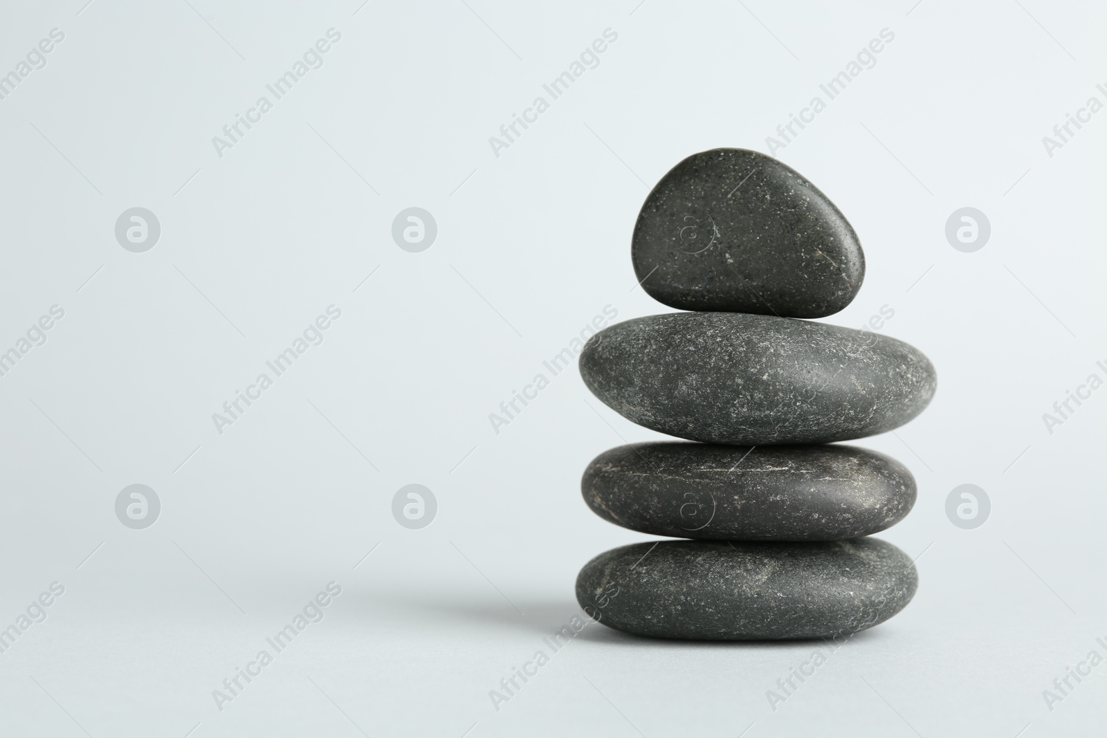 Photo of Stack of rocks on light background, space for text. Harmony and life balance