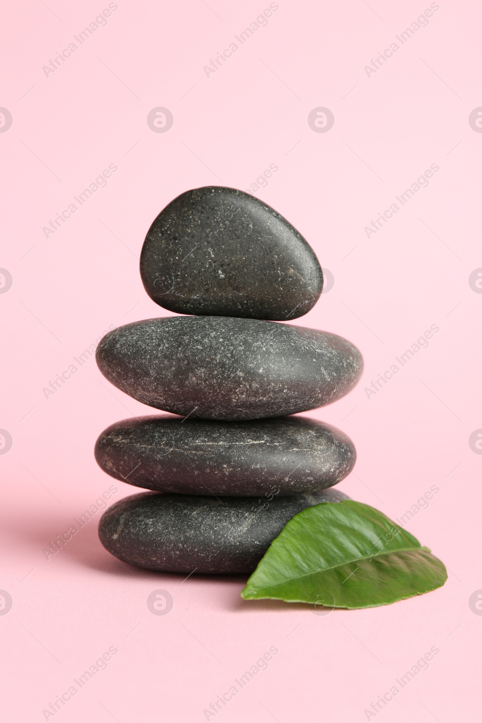 Photo of Stack of rocks on light pink background. Harmony and life balance