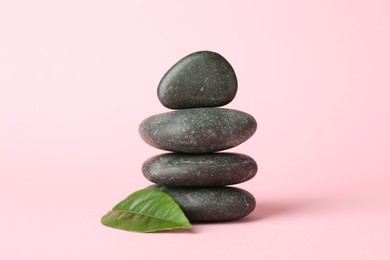 Photo of Stack of rocks on light pink background. Harmony and life balance