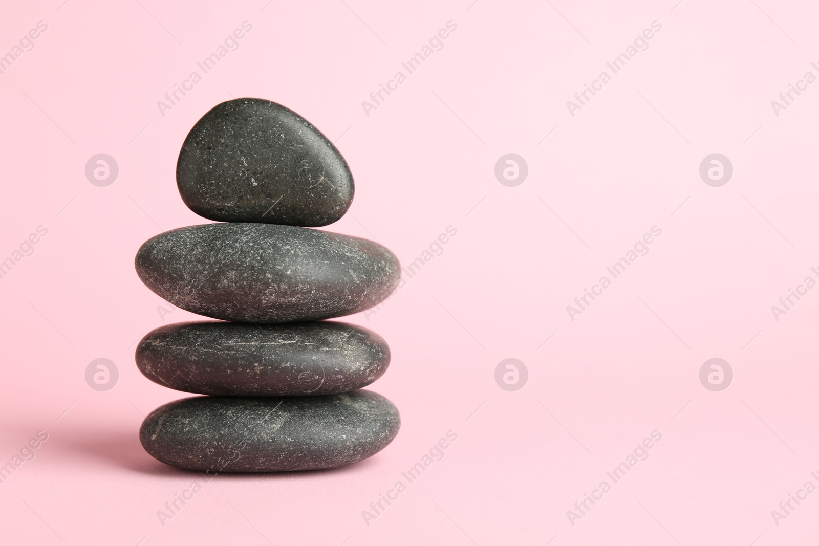 Photo of Stack of rocks on light pink background, space for text. Harmony and life balance