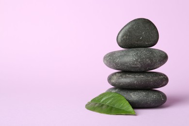 Photo of Stack of rocks on lilac background, space for text. Harmony and life balance