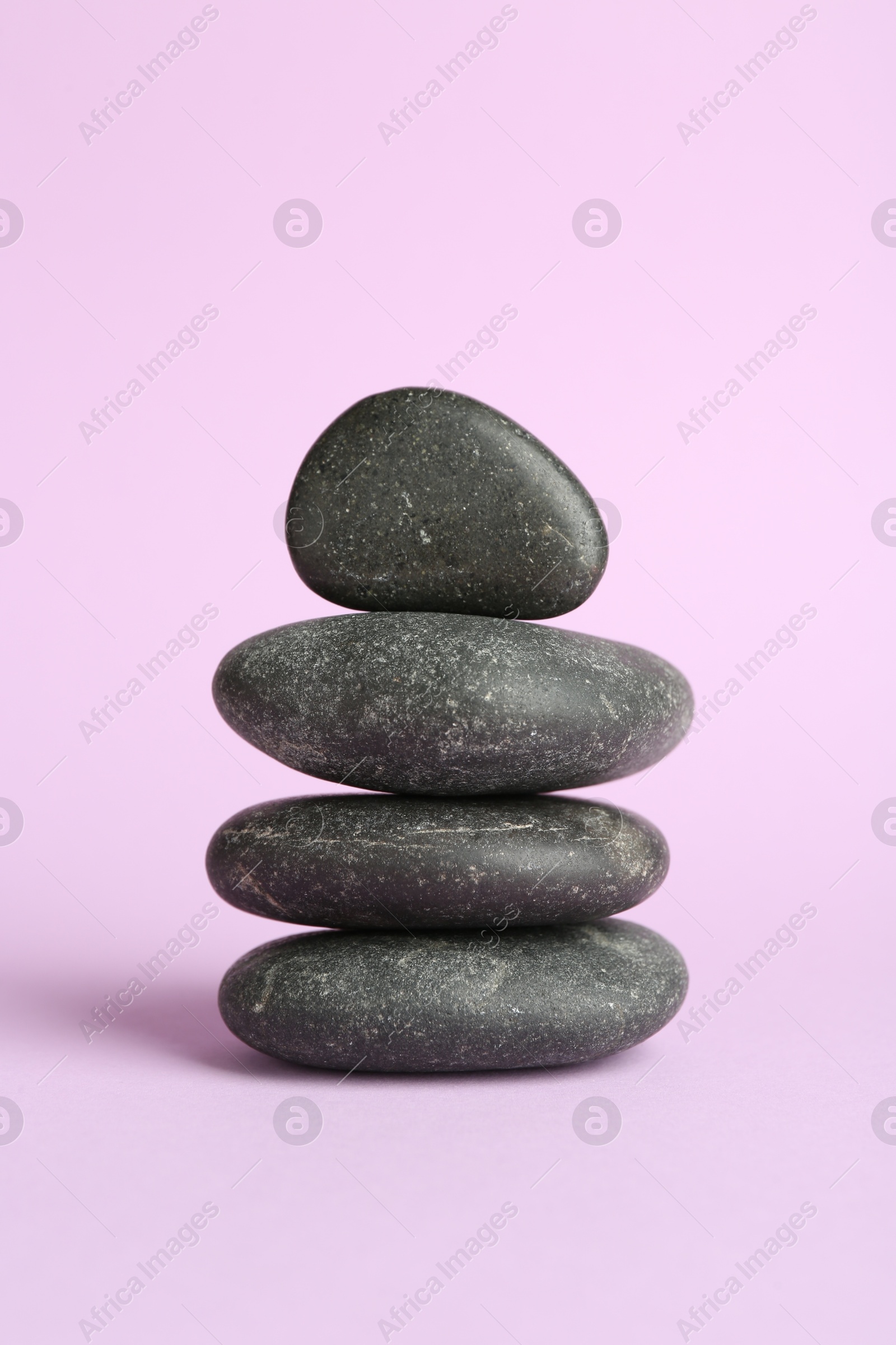 Photo of Stack of rocks on lilac background. Harmony and life balance