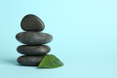 Photo of Stack of rocks on light blue background, space for text. Harmony and life balance