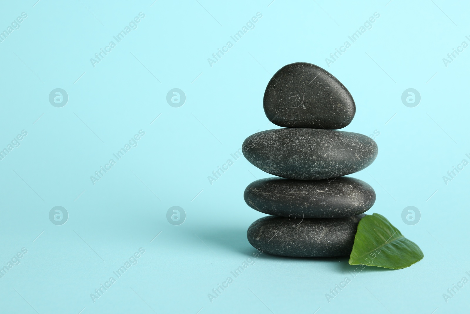 Photo of Stack of rocks on light blue background, space for text. Harmony and life balance