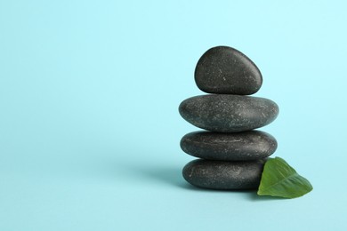 Photo of Stack of rocks on light blue background, space for text. Harmony and life balance