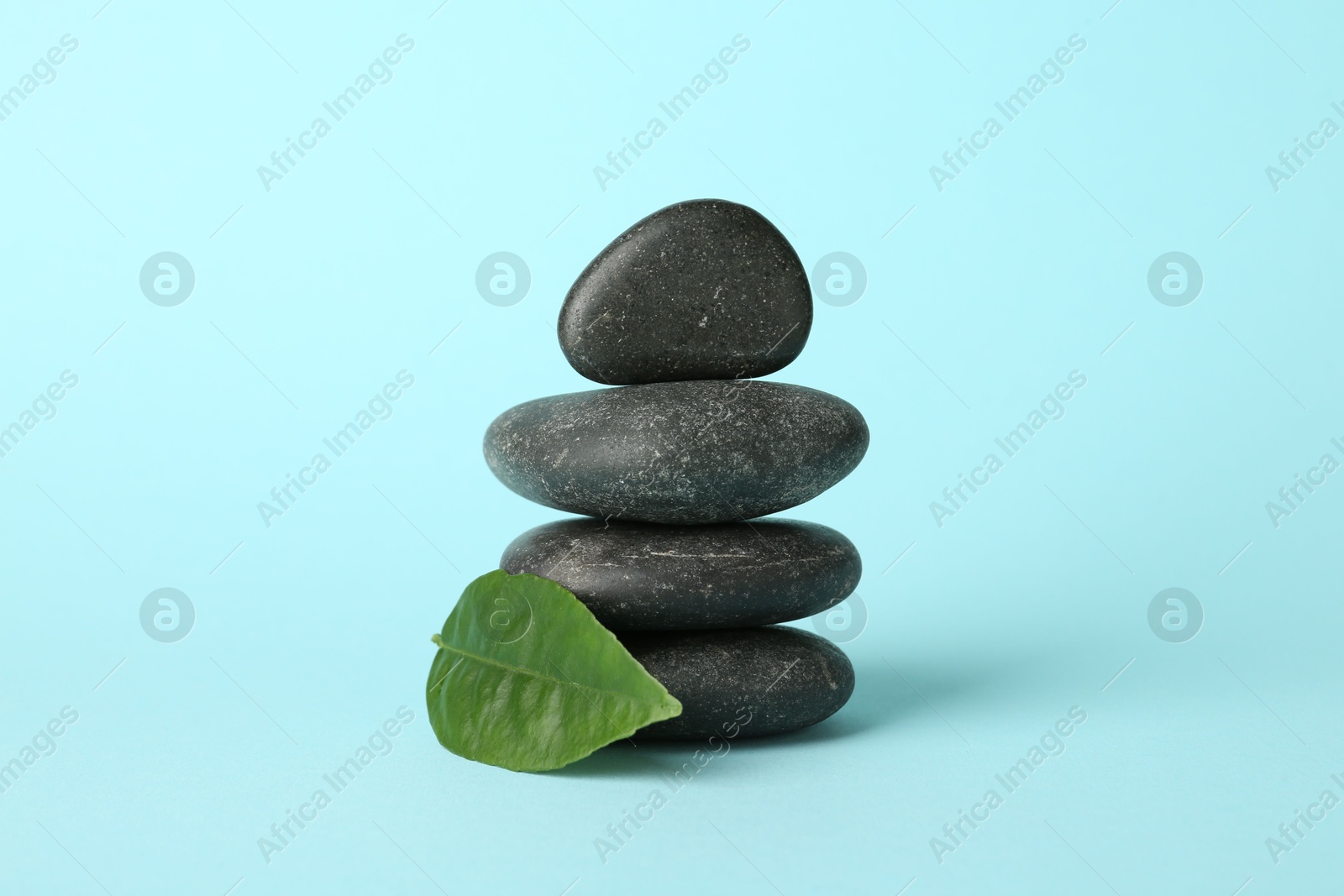 Photo of Stack of rocks on light blue background. Harmony and life balance