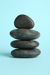 Photo of Stack of rocks on light blue background. Harmony and life balance