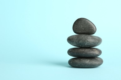 Photo of Stack of rocks on light blue background, space for text. Harmony and life balance