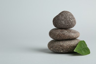 Photo of Stack of rocks on light grey background, space for text. Harmony and life balance