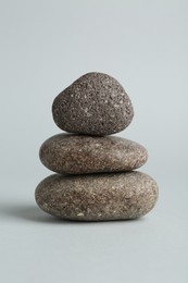 Photo of Stack of rocks on light grey background. Harmony and life balance