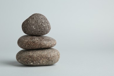 Photo of Stack of rocks on light grey background, space for text. Harmony and life balance