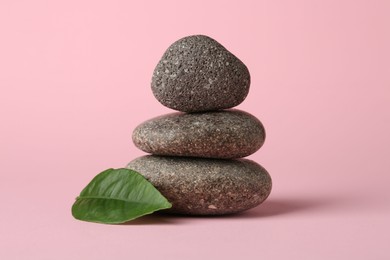 Photo of Stack of rocks on light pink background. Harmony and life balance