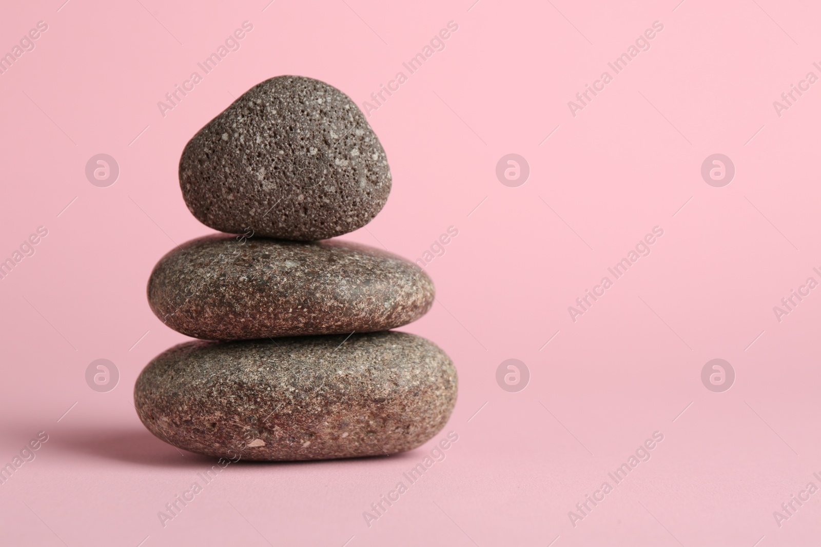 Photo of Stack of rocks on light pink background, space for text. Harmony and life balance