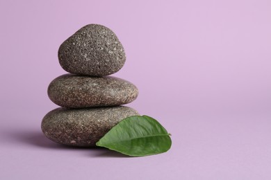 Photo of Stack of rocks on lilac background, space for text. Harmony and life balance